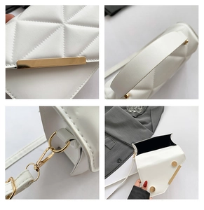 Detail view of white quilted crossbody bag with gold metal clasp and magnetic closure