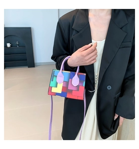 Detail of colorful geometric pixel pattern handbag shown as a crossbody on model