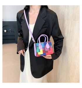 Detail view of colorful geometric tetris pattern handbag with a purple top handle