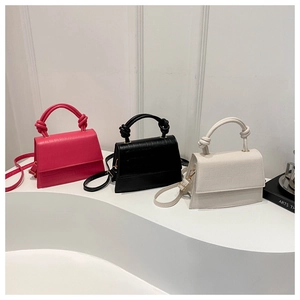 Three minimalist crocodile-patterned handbags in pink, black, and white colors