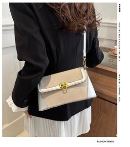 Detail of straw patchwork crossbody bag with gold twist lock and shoulder strap
