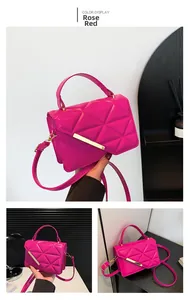 Detail of rose red crossbody bag featuring triangular quilting and metallic bar