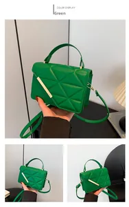 Close-up of green quilted small square bag with elegant gold metal buckle and PU texture