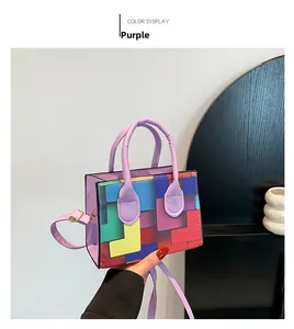 Detail of purple handbag featuring colorful tetris geometric patterns and side handle