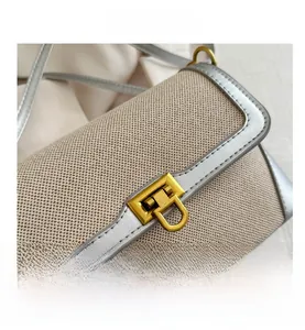 Close-up of vintage canvas bag with metallic buckle and elegant leather piping detail