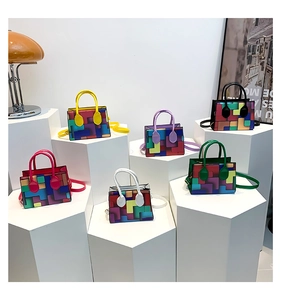 Colorful geometric patchwork mini handbags in diverse colors on modern pedestals