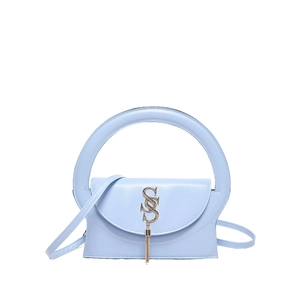 Chic light blue crossbody bag with round handle and gold tassel logo in minimalist studio shot