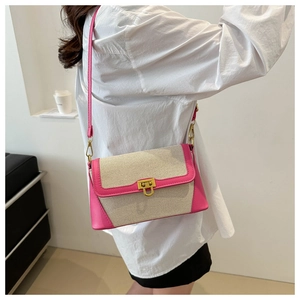 Detail of pink leather and beige woven crossbody bag with gold U-shaped metal buckle