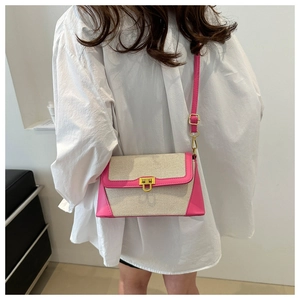 Detail of contrast stitch straw box bag with vibrant pink leather trim and gold twist lock