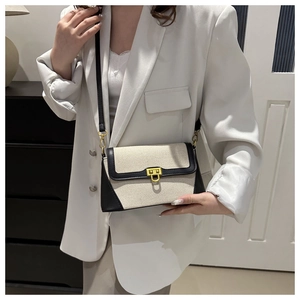 Detail of the chic canvas baguette bag with black leather trim and gold twist lock
