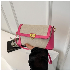 Detail of a straw woven crossbody bag featuring pink leather trim and gold metal buckle