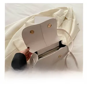 Dettaglio dello scomparto interno e delle fibbie magnetiche di una borsa a tracolla in pelle