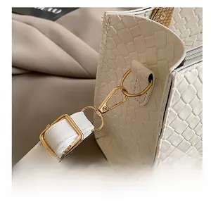Detailed close-up of premium white snakeskin embossed leather and golden metal hook
