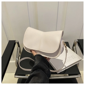 Dettaglio borsa a sella bianco crema con texture in pelle PU e finiture dorate lucide