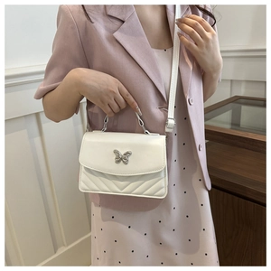 Détail du sac bandoulière avec boucle papillon argentée et cuir PU matelassé en V