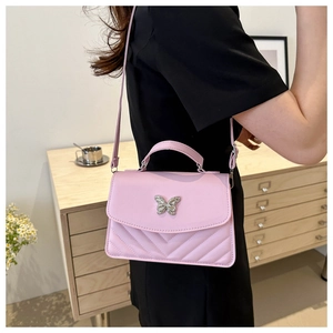 Détail du petit sac bandoulière rose matelassé avec fermoir papillon argenté élégant