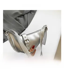 Close-up of silver dumpling bag with metallic chain trim and adjustable belt strap