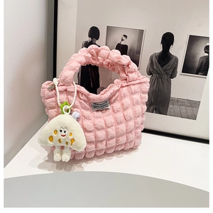 Detailed texture of pink bubble fabric handbag with a cute mushroom pendant accessory
