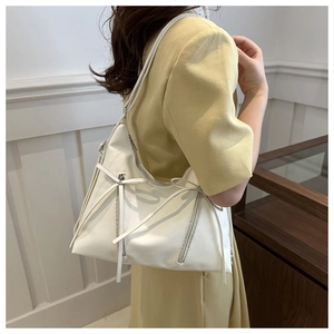 Detail of white PU leather tote bag showing vertical zipper and bow tie knot features