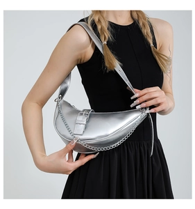 Detail of silver metallic hobo bag with chain strap and buckle on black dress