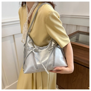 Dettaglio borsa tote in PU argento con fiocchi decorativi e finitura metallica lucida