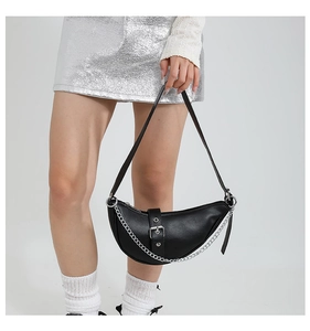 Detail of black crescent shoulder bag with silver chain and matte leather texture