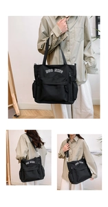 Detail of black canvas tote with letter embroidery showing multiple carrying styles