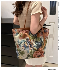 Dettaglio borsa tote vintage in jacquard floreale con manici in pelle marrone e cuciture