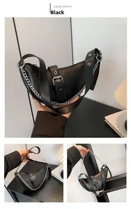 Detail view of black crescent shoulder bag with silver chain and metal eyelet strap