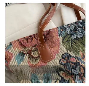 Detail of floral tapestry tote with reinforced brown leather strap and stitching