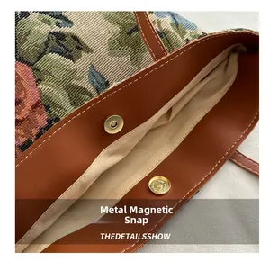 Detail of flower tapestry bucket bag featuring magnetic snap closure and leather trim