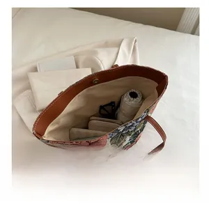 Detail view of floral tote bag interior capacity with leather straps and magnetic closure
