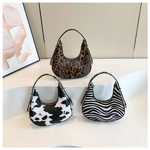 Three half-moon handbags in stylish leopard, cow, and zebra patterns with top handles