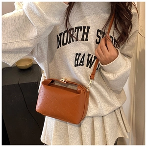 Detail of caramel brown crossbody bag with rich rabbit embossed pattern and gold buckle