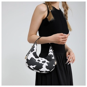 Chic hobo shoulder bag with black and white cow print and minimalist metal buckles
