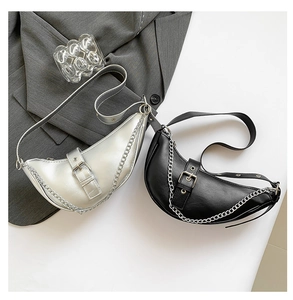 Detail of crescent shoulder bags in silver and black with chic metal chain decor