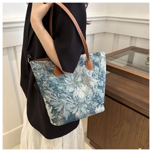 Vintage floral jacquard tote bag with brown leather straps shown on shoulder