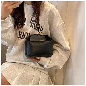 Close-up of the rich rabbit embossed pattern and gold lock on this black mini handbag