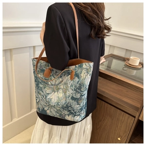 Dettaglio della borsa tote in tela a fiori con trama jacquard e spalline in pelle marrone