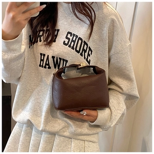 Close-up of brown leather handbag featuring rich rabbit lettering embossed details