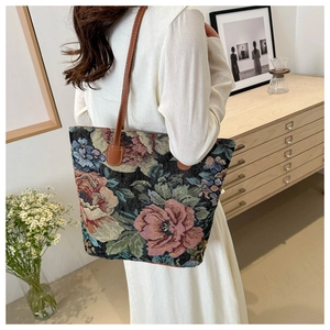 Detail of vintage floral tapestry tote bag with brown leather straps in a cozy room
