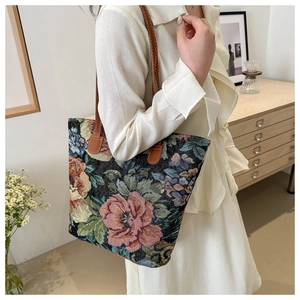Detail of vintage floral jacquard tote bag with brown leather straps and rose pattern