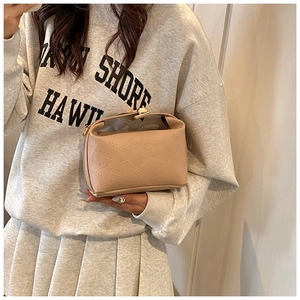 Detail showing apricot faux leather bag with rich rabbit embossing and gold metal clasp