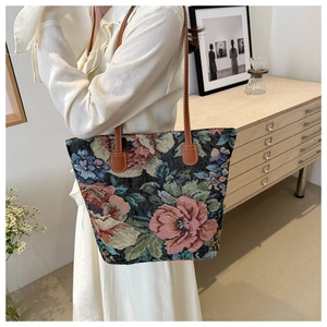 Dettaglio macro del tessuto jacquard vintage e del ricamo a rose su una grande borsa tote