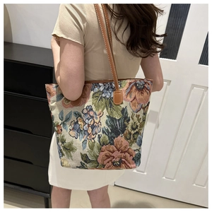 Detailed close-up of vintage floral tapestry tote bag with brown leather straps