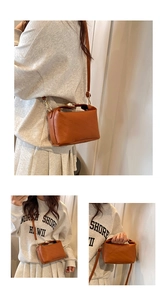 Detail of brown square crossbody bag featuring embossed rich rabbit texture and gold hardware
