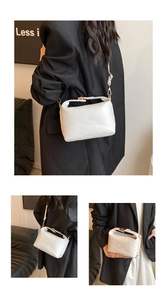 Detail of white embossed leather handbag with rich rabbit pattern and gold clasp