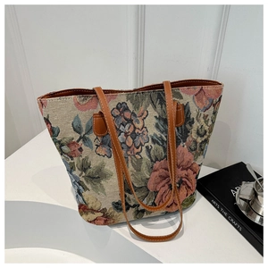 Dettaglio della borsa tote in arazzo floreale con manici in ecopelle marrone su bianco