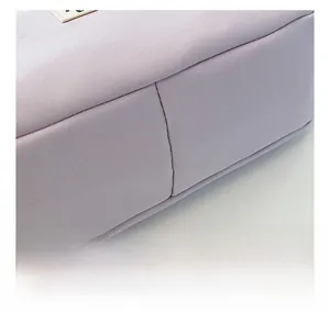 Macro shot of precise stitching and woven texture on a lilac canvas saddle bag