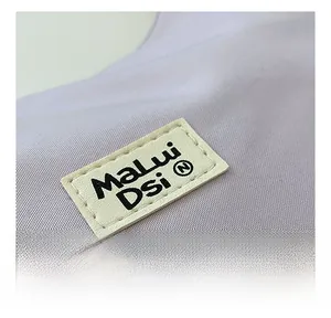 Detailed close-up of light purple canvas bag with stitched faux leather logo patch